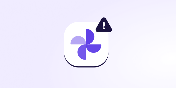 A stylized icon resembling the Google Photos logo with a dark triangular warning sign containing an exclamation mark, representing Google Photos safety issues